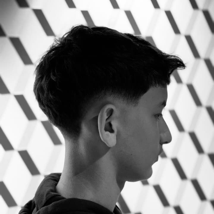 Low Fade réalisé dans notre barbershop à Chalon-sur-Saône. Un dégradé travaillé avec précision, offrant un fondu propre, net et parfaitement structuré par nos barbiers experts du Centre Commercial Carrefour Chalon Sud. Votre référence à Chalon-sur-Saône p