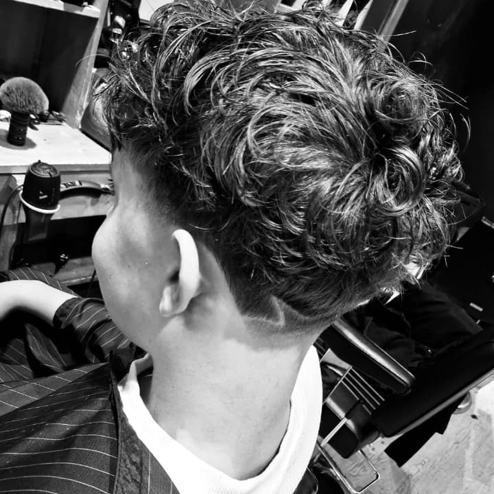 Taper réalisée dans notre barbershop The Barber Company Chalon-sur-Saône. Un dégradé progressif, propre et maîtrisé par nos barbiers experts du Centre Commercial Carrefour Chalon Sud, pour une finition nette et moderne. Votre adresse à Chalon-sur-Saône po